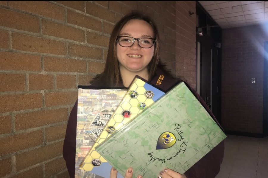 Junior Kasey Palmer, co-editor in chief, shows previous yearbook covers. For $70, buyers this year will receive two hardcover books, one of which will be given out in May.