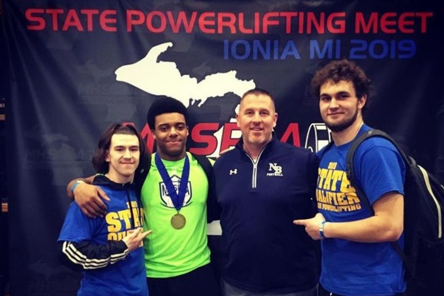 Senior Eddie Harris (second from left) celebrates with teammates -- senior Dylan Buschur (left) and junior Matthew Mcginnis (right) -- and his former football coach, Mr. Jeremy Furman, after winning a powerlifting state title in Ionia on Saturday, March 9. 