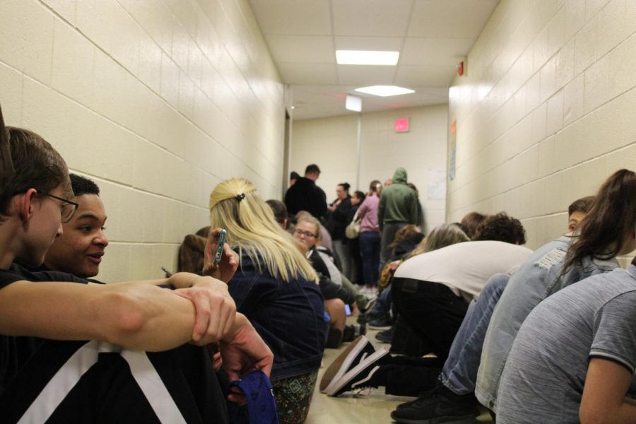 Students and parents take cover in the hallways surrounding the auditorium Thursday, March 14, as a tornado warning interrupted Foreign Language Variety Night.