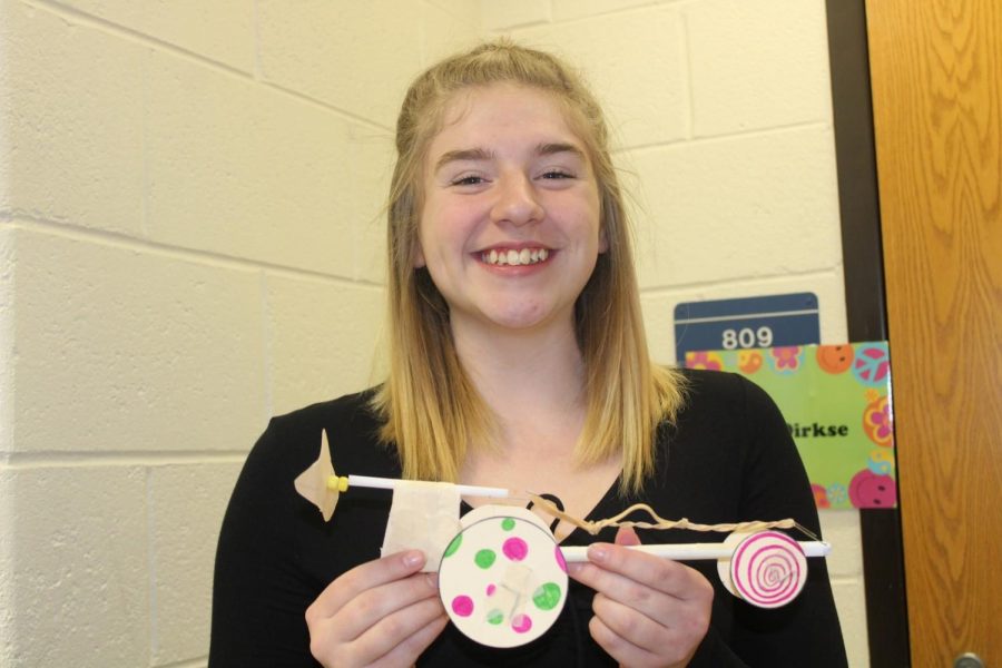 Senior Madison Kreinbrink shows off the car she and her group made in physics class Tuesday, March 19.