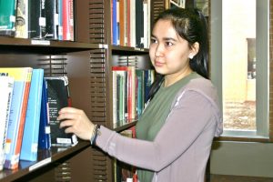Senior Datkaaiym Talieva checks out a book in the library.