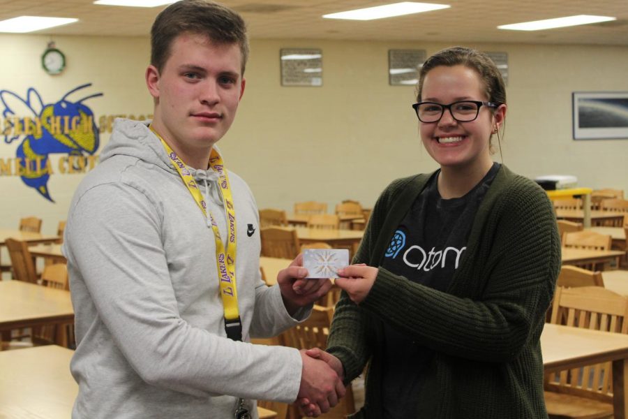 Senior Hunter May (left) won first place in the Eclipse March Madness Challenge and received a $10 gift card to a local restaurant, which was presented to him by The Eclipse editor in chief Jenna Robinson.