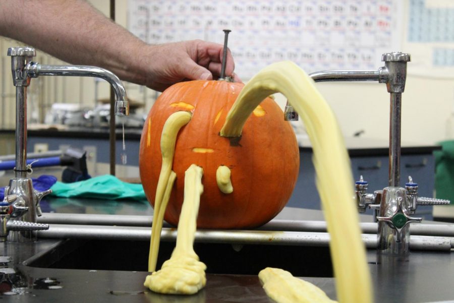Foam shoots out of a pumpkin after Mr. Kelly Christian, chemistry teacher, put goat's blood in it in the chemistry lab Thursday, Oct. 31. The blood and pumpkin react to form the foam.