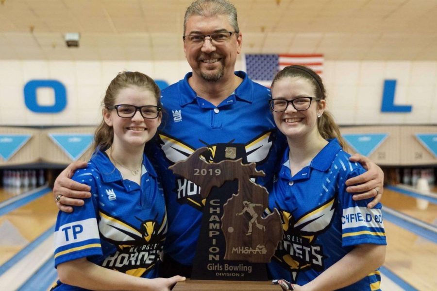 Junior+Megan+Timm+%28l+to+r%29%2C+Coach+Rob+Ploof+and+senior+Samantha+Timm+hold+the+MHSAA+Division+2+state+championship+trophy.+The+Hornets+will+look+to+win+their+seventh+state+title+in+a+row+this+season.