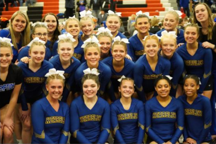 The competitive cheer team smiles after their seventh place ranking at the Metro League District Finals