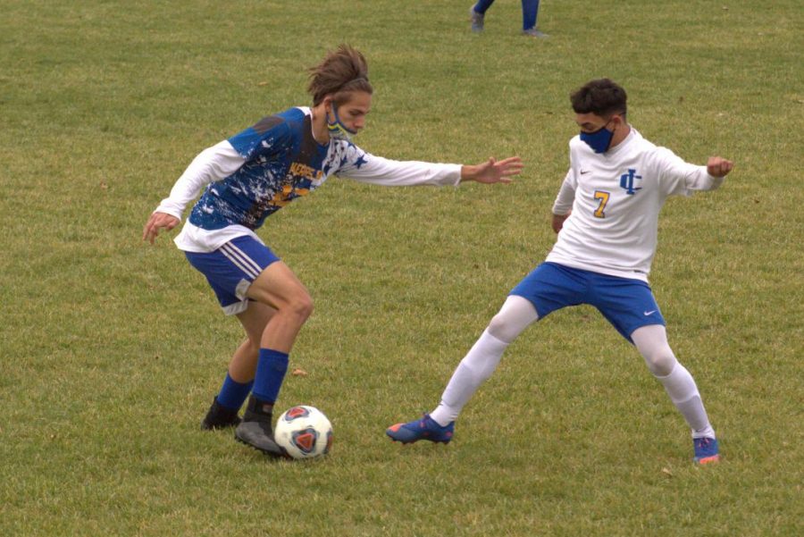 Junior Cy Cooper (left) keeps the ball away from an Imlay City player Monday, Oct.19.