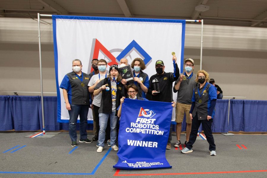 The team and advisors pose with blue medals and the coveted blue banner.