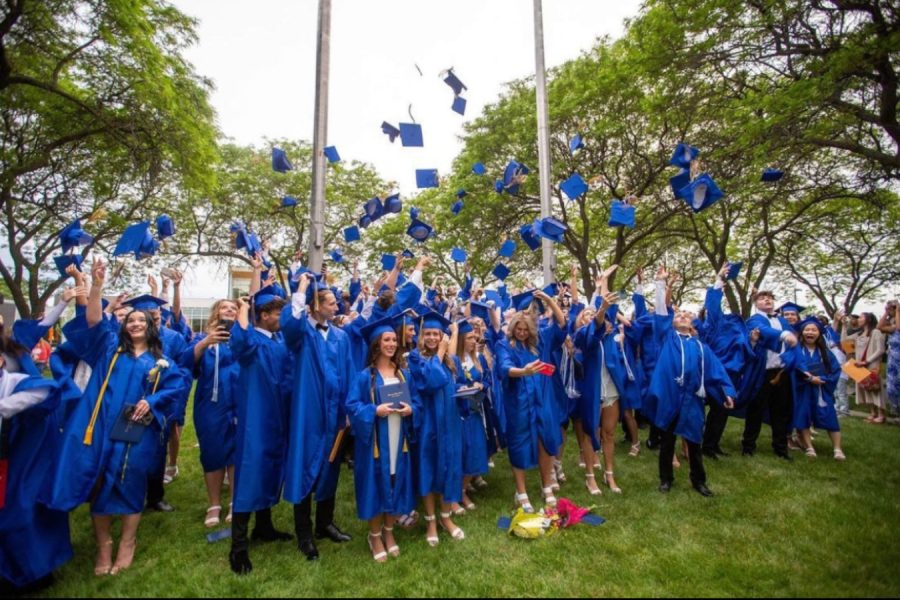 Now,kearsley high school  alumis throw caps into air in excitement.