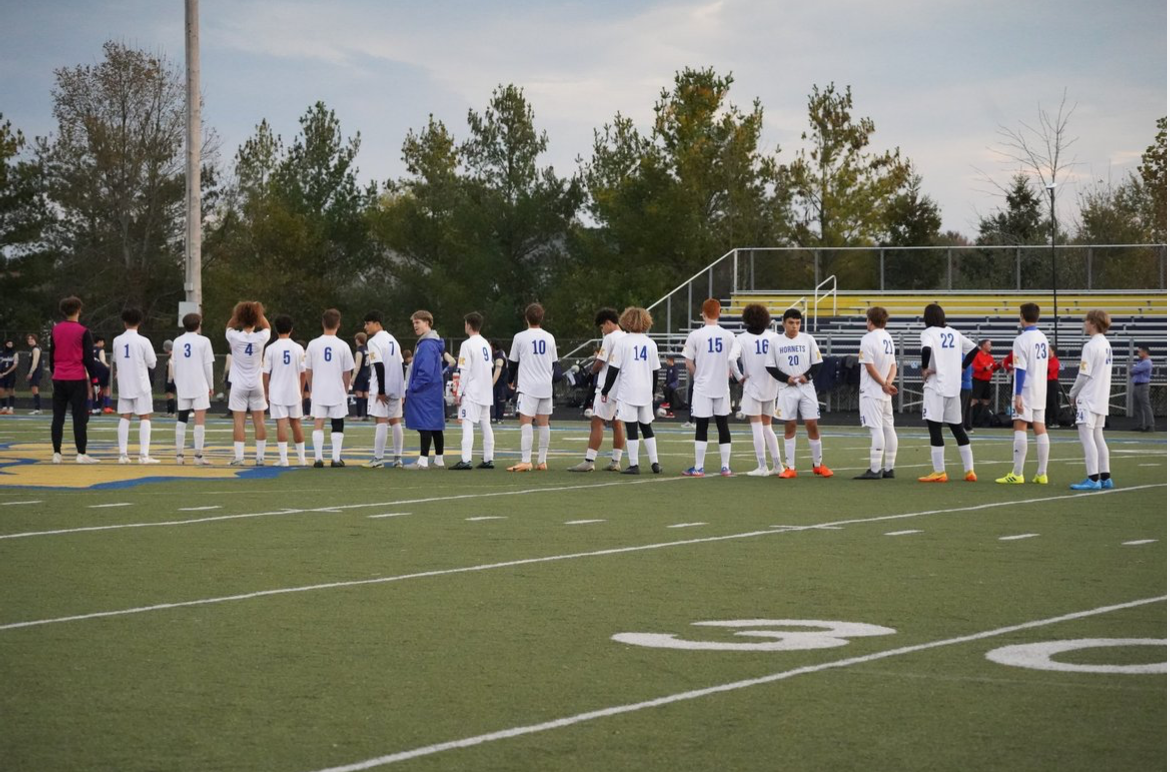 The+Kearsley+Varsity+Boys+Soccer+Team+is+all+lined+up+for+the+national+anthem+just+moments+before+kickoff+against+the+Goodrich+Martians+for+the+district+championship.