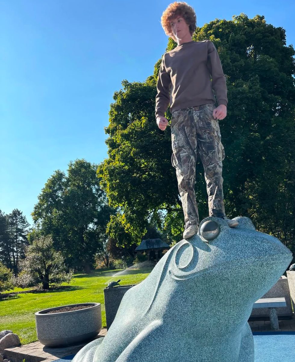 Owens showing his silly side standing on a frog statue. 